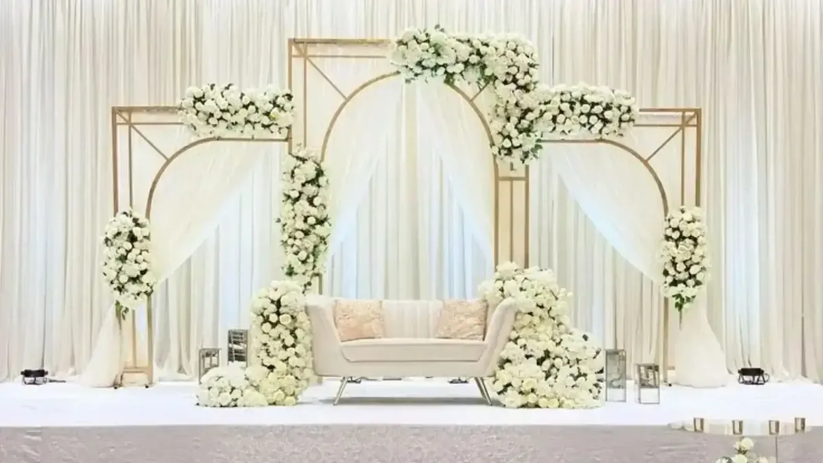 Gold arch trio with ivory drapes and white roses